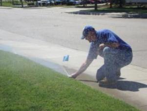 James, a professional Richmond Hill sprinkler repair contractor, adjusts a Rain Bird pop up sprinkler head
